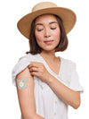 FreeStyle Libre 2 butterfly shape patch worn on a woman’s arm, with breathable adhesive fabric for sensor support