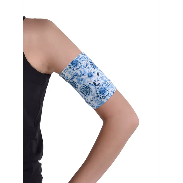 Blue floral glucose monitor and insulin pump armband worn on upper arm for active diabetes management.