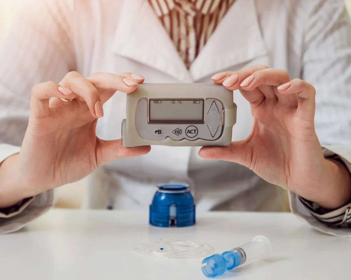 person holding blood glucose meter device with insulin pump components showing diabetes device maintenance and usage Bild