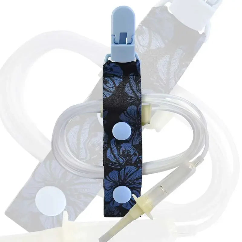 Kaio-Tube Clip with blue floral fabric and light blue buttons, securing medical tubing for organized and comfortable wear. Bild