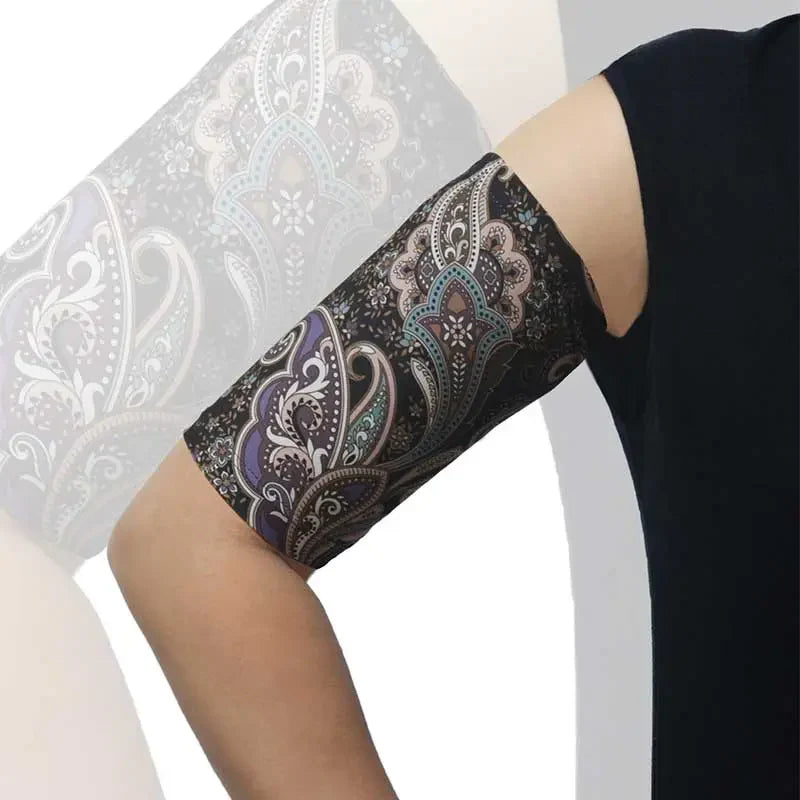 PICC line arm sleeve with a black background and colorful paisley pattern, worn on an arm for comfortable, protective daily use. Bild