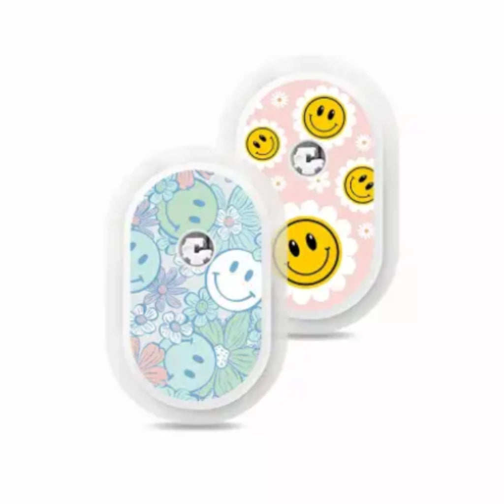 Sibionics GS1 CGM devices with colorful vinyl stickers, featuring smiley faces and floral designs. Bild
