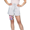 Woman wearing a colorful compact diabetic leg pack secured with adjustable straps on upper thigh.