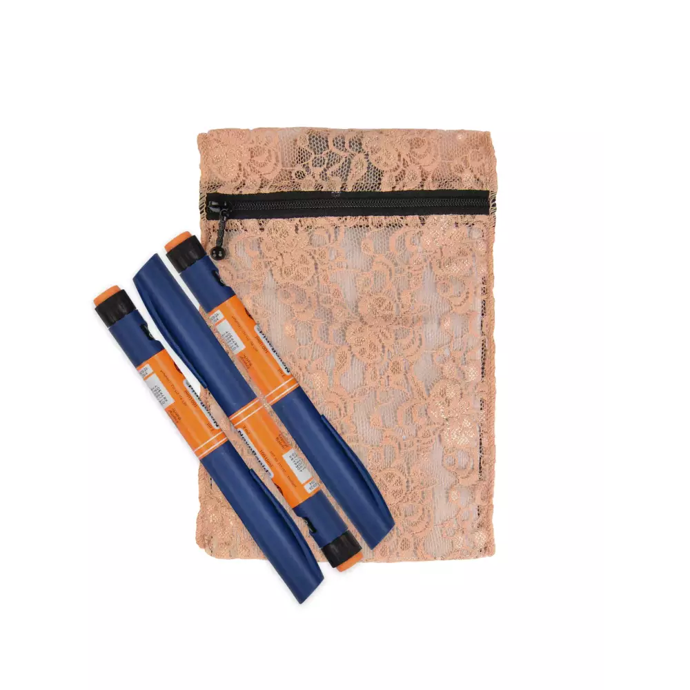 Insulin cooling wallet in lace design holding orange insulin pens.