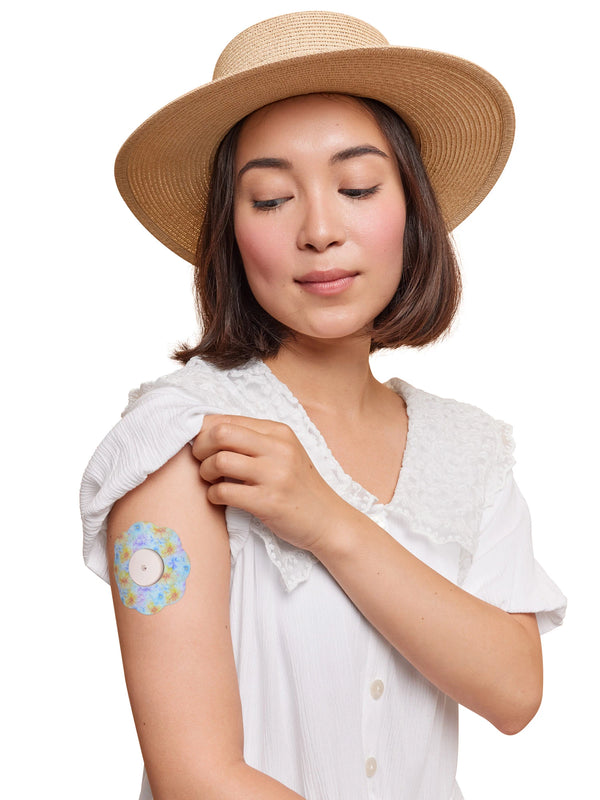 FreeStyle Libre 2 cookie shape patch worn on a woman’s arm, with breathable adhesive fabric for sensor support