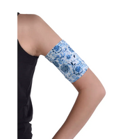 Blue floral glucose monitor and insulin pump armband worn on upper arm for active diabetes management.
