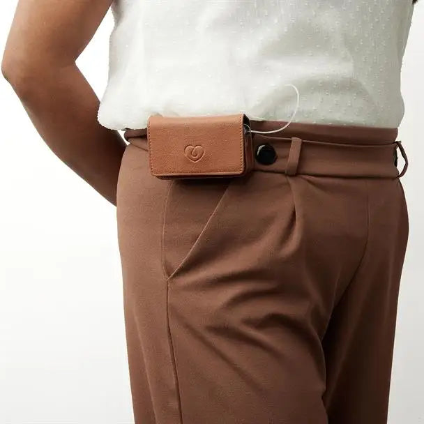 Leather insulin pump holder worn on a belt for secure and stylish diabetes management.